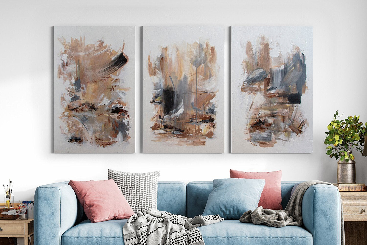 a living room with a blue couch and paintings on the wall